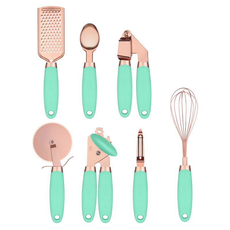 Rose gold kitchen tool set with copper plating, including a peeler, whisk, garlic press, pizza cutter, and other essential gadgets.
